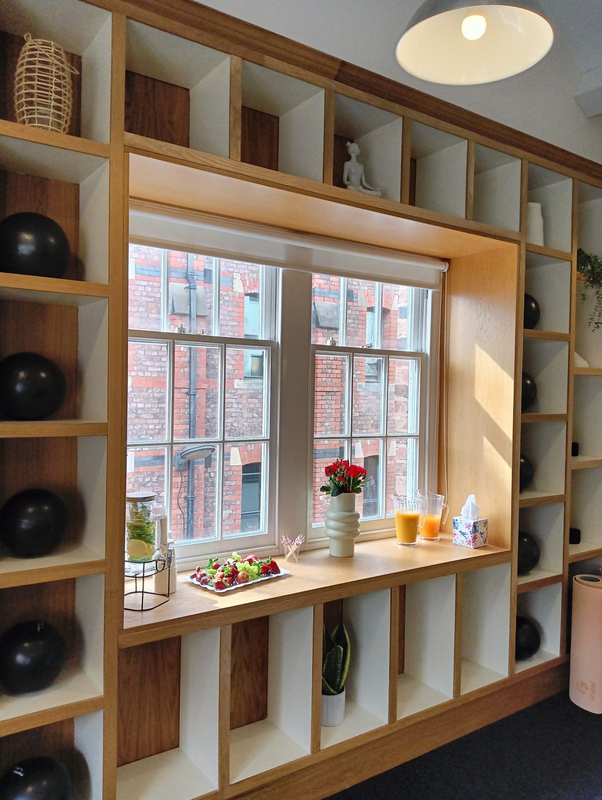 The window seat in the oak shelving, with juice and fruit set out on the sill
